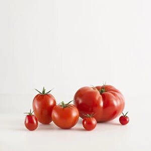 Assorted red tomatoes, including cherry tomatoes, plum tomato, beefsteak tomato
