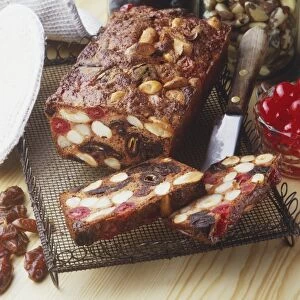 Dried fruit and brazil nut loaf cake on a wire tray, two slices removed