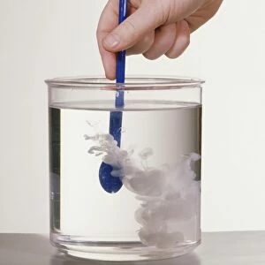 Stirring milk into water in a glass beaker