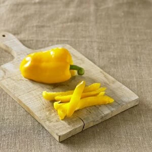 Yellow bell pepper cut into strips on chopping board