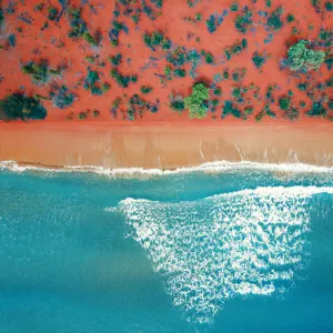 Aerial top view of a bright orange sandy beach