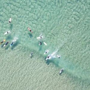 crystal clear waters with surfers seen from above