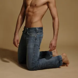 Bare-chested man in jeans, kneeling