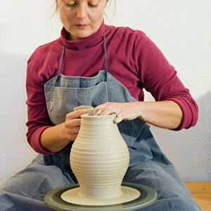 Ceramic artist working in her workshop with a potters wheel, turning a vase, Geisenhausen, Bavaria, Germany, Europe