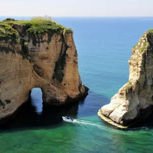 Excursion boat off the Pigeons Rock, Grotte aux Pigeons, limestone rocks eroded by wind and weather in the Raouche district, Beirut, Lebanon, Middle East, Asia