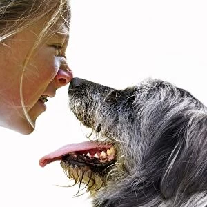 Girl and dog sniffing each others noses