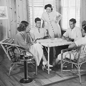 Group of young people playing cards (B&W)