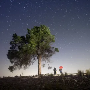 Two persons camiando with suitcases in the night