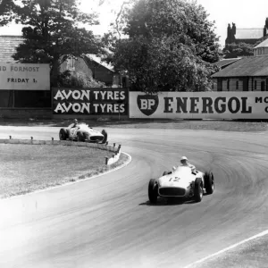 British racing driver Stirling Moss No 12, takes the lead from Fangio of Argentina