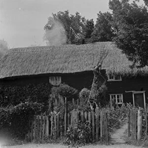 A man thatching the roof of a cottage in Hartley, Kent. 10 June 1937