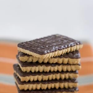 Stack of chocolate ginger biscuits on orange napkin credit: Marie-Louise Avery