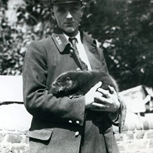 Keeper Leslie Martin Flewin cradles an otter pup in his arms at London Zoo