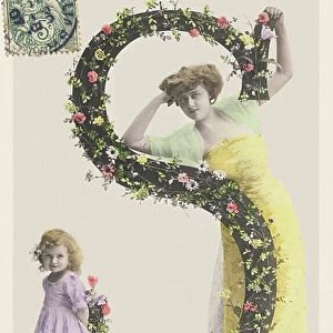 S: Capital letter decorated with flowers, a woman wearing a long sheet and a girl in a short dress. 1907 (photograph)