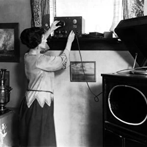 A woman tuning an early crystal radio set Long Island NY, c. 1910 (b / w photo)