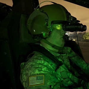 Pilot equipped with night vision goggles in the cockpit of an Apache helicopter