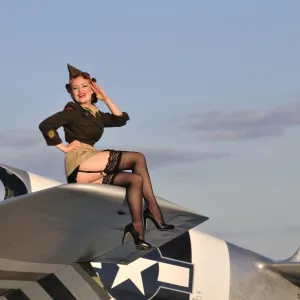 Pin-up girl sitting on the wing of a P-51 Mustang