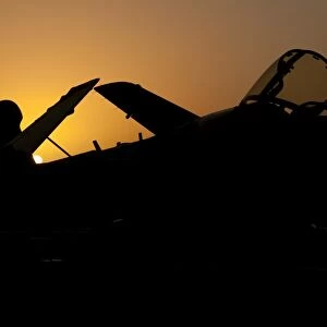 Silhouette of an EA-6B Prowler at sunrise on the flight deck of USS Nimitz