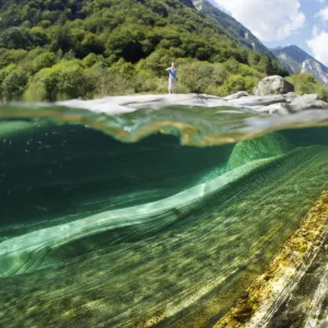 Split level view of blue green waters of Verzasca River flowing over granite rocks at Lavertezzo