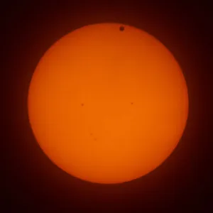 The transit of Venus across the face of the sun, with visible sunspots, as seen from Aurora