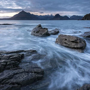 Waves washing up Elgol beach in the evening light with a view of the Cuillins, Strathaird