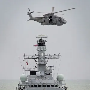 Royal Navy Type 23 Frigate HMS Sutherland with a Merlin Helicopter Overhead