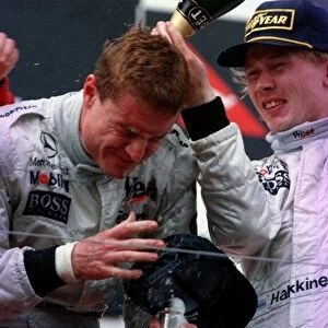 1997 AUSTRALIAN GP. David Coulthard wins the race and celebrates on the podium with team mate and 3rd placed driver, Mika Hakkinen. Photo: LAT