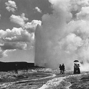 Historic image in black and white of tourists at Old Faithful geyser, Yellowstone National Park, circa 1900; Wyoming, United States of America