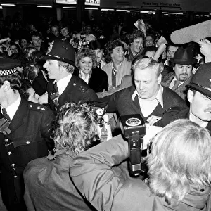 Barry Manilow and Roberta Kent surrounded by his many fans as he leaves Heathrow Airport