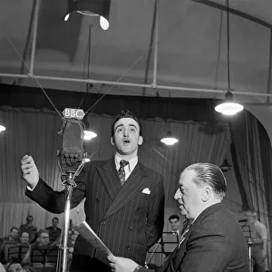 BBC Producer Leslie Bridgemont holds the songsheet for the Singing Waiter as he sings