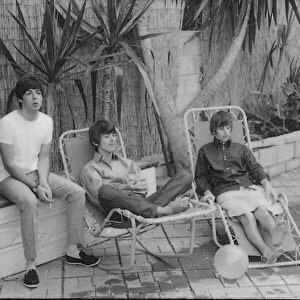 Beatles left to right: Paul McCartney, George Harrison and Ringo Starr relaxing in sun