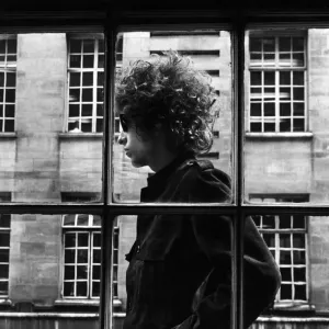 The one and only Bob Dylan pictured walking past a shop window in London, 3rd May 1966