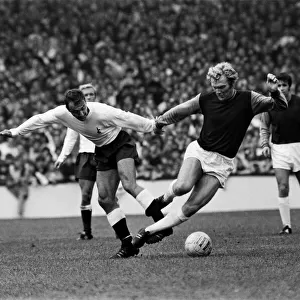 Bobby Moore of West Ham is tripped by Tottenham Hotspur forward Jimmy Greaves during