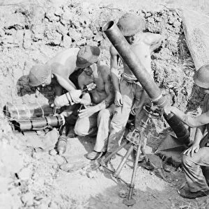 British Troops loading up mortar with bombs during Second World War in desert