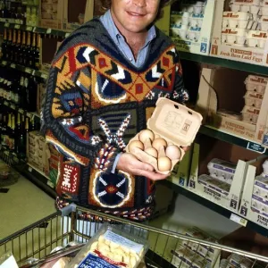 Bruno Brookes Disc jockey and TV Presenter holding open a carton of eggs while doing