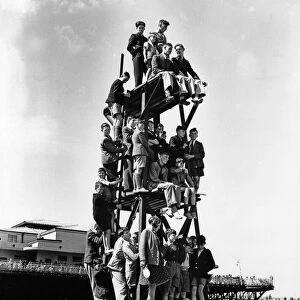 Children make a human pyramid on a lifeguard look-out tower at a Butlins holiday camp