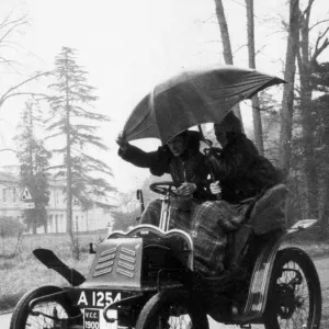 A couple in a 1900 Pieper shelter from the freezing rain during the veteran London to