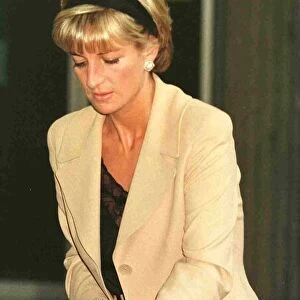 Diana, Princess of Wales, wearing sand coloured suit with black top and matching headband