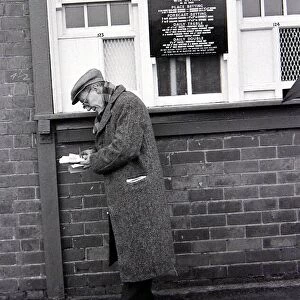 An elderly man holding his receipts after placing a bet on the tote before a race