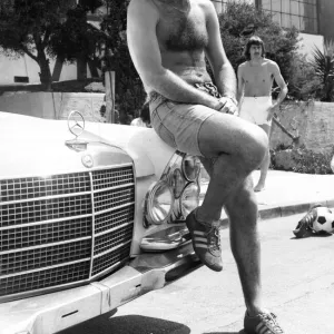 Footballer George Best poses beside his Mercedes Car June 1976