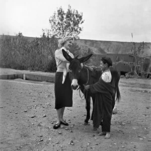 A French actress meets a local boy and his donkey in the countryside of Morocco