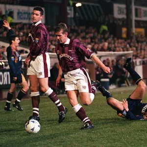 Gary Mackay of Hearts Football Club runs with the ball after tackling Paul Bernard of