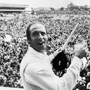 Geoff Boycott with a stump and a glass of champagne after scoring his 100th century in