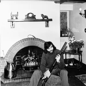 George Best seen here cleaning his gun at home May 1974