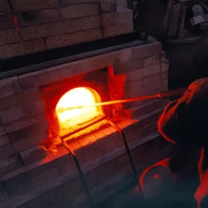 Glass blower Andy Murphy works on one of the furnaces in November 1997