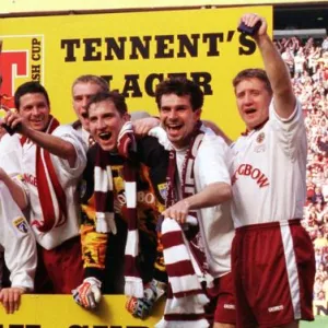 Heart of Midlothian footballers celebrate with the Scottish Cup trophy after defeating