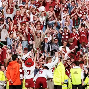 Heart of Midlothian footballers show off the Scottish Cup trophy to jubilant fans on a
