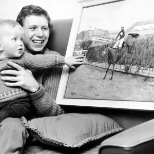 Jockey Brian Fletcher pictured showing his son Andrew a painting of Red Rum landing over