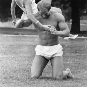 Linda Lusardi being lifted by a muscley nearly naked Julien Mess in the park