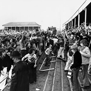 Manchester United fans celebrate on the pitch at Meadow Lane after a 2-2 draw against