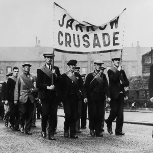 Des chômeurs marcheurs de Jarrow en uniforme portant un drapeau avec l'inscription.